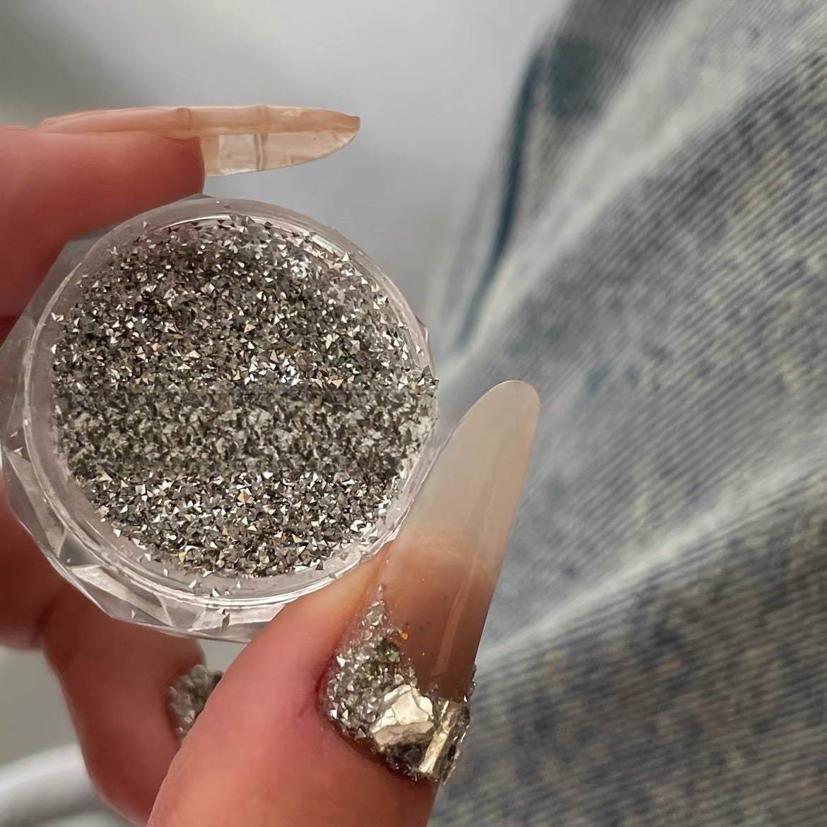 A Box of Tiny Silvery Triangular 3D Glittering Rhinestones, Perfect for Parties, Nightclubs, Music Festivals, And Vacation Nail Art Accessories.