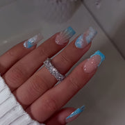 A Set of 24 Full-Cover Press-On Fake Nails Featuring Blue Wave Designs, Sparkling Diamonds, And Cloud Patterns in a Blue French Style, Along with Three-Dimensional Gel Stripes. These Medium Square-Shaped Fashionable Press-On