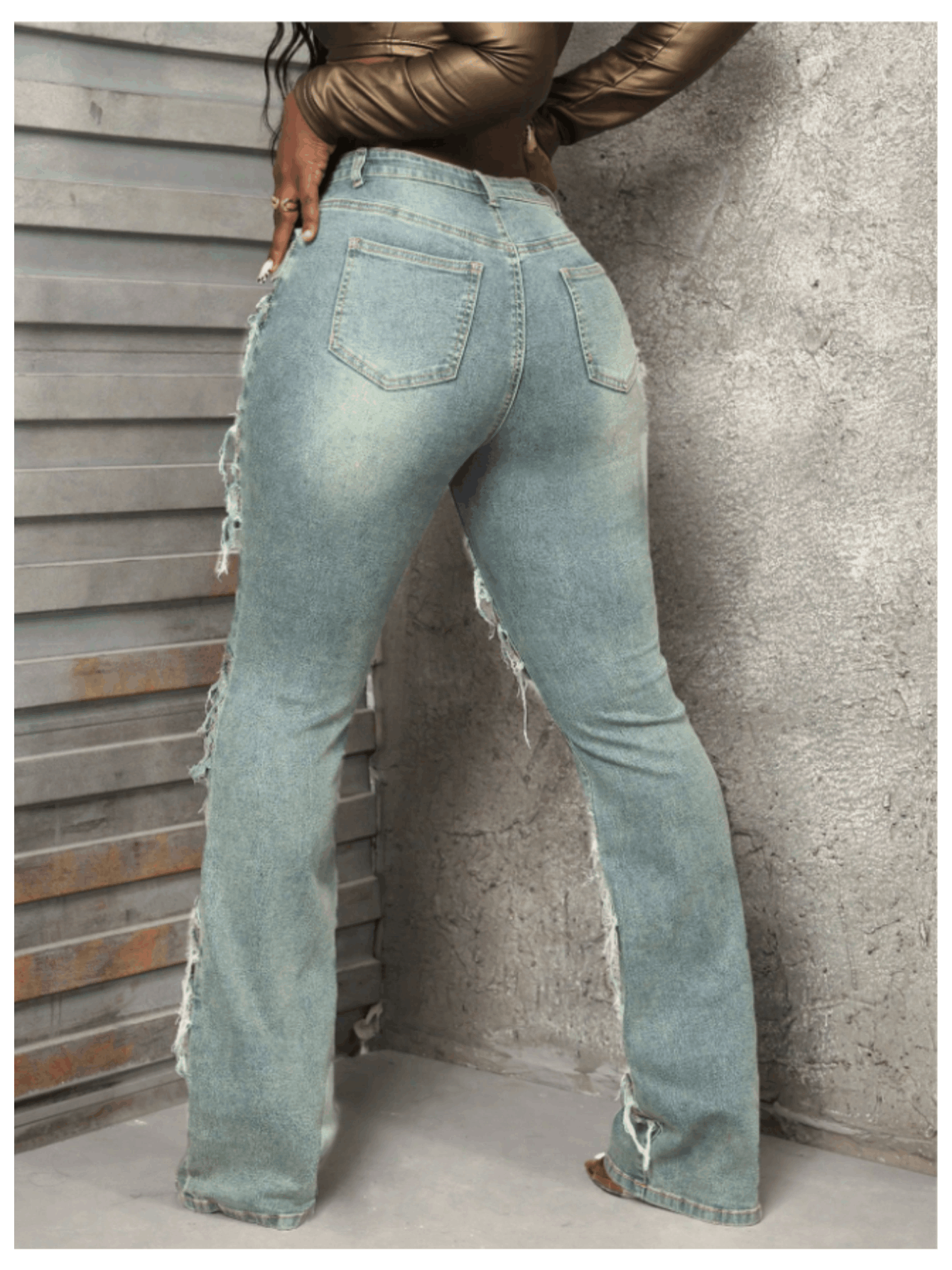 Vintage-style women's water-washed distressed pants with slit at the hem, made of denim fabric.