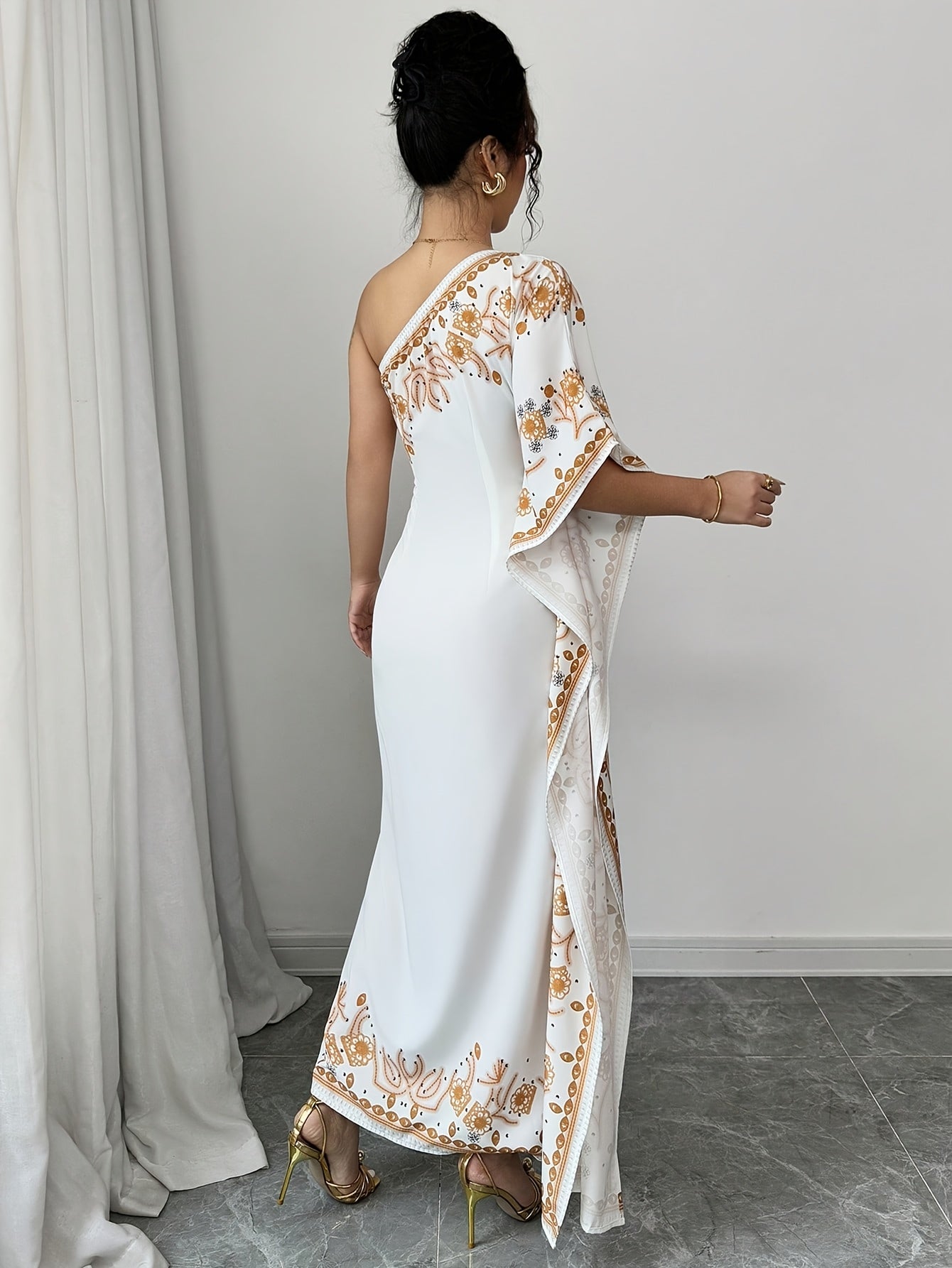 An Elegant Long Dress with an Asymmetrical Floral Print on The Shoulder, Suitable for Formal Occasions.