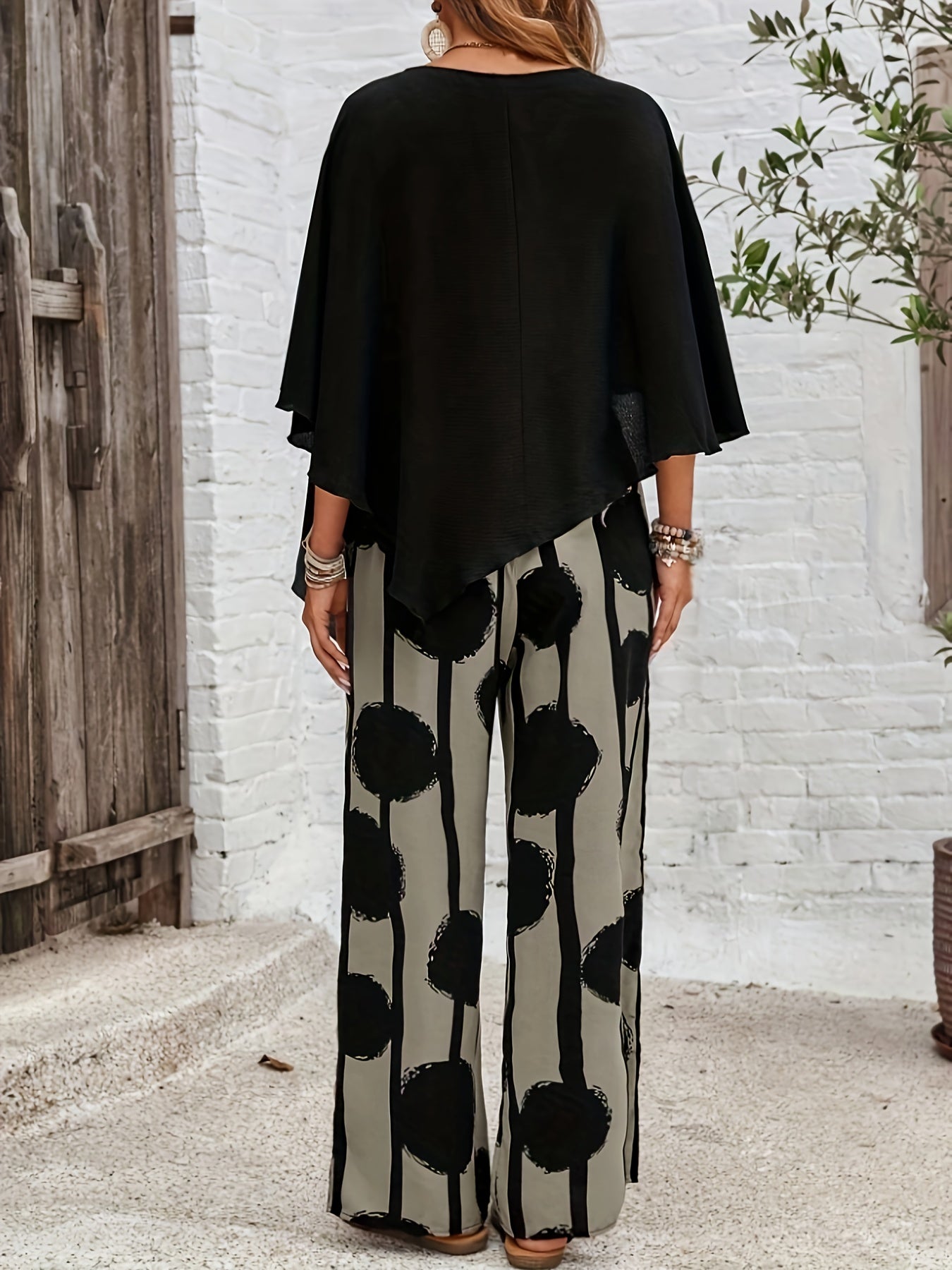 A Two-Piece Women'S Solid Color Round Neck Asymmetrical Hem Shirt And All-Over Printed Pants Set.